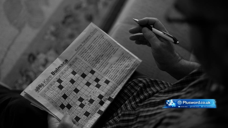 A person filling out clues while learning how to solve crossword puzzles