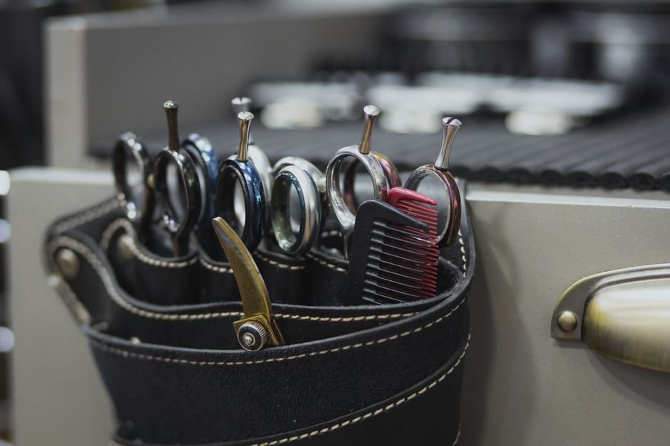 barber using scissors for low taper fade