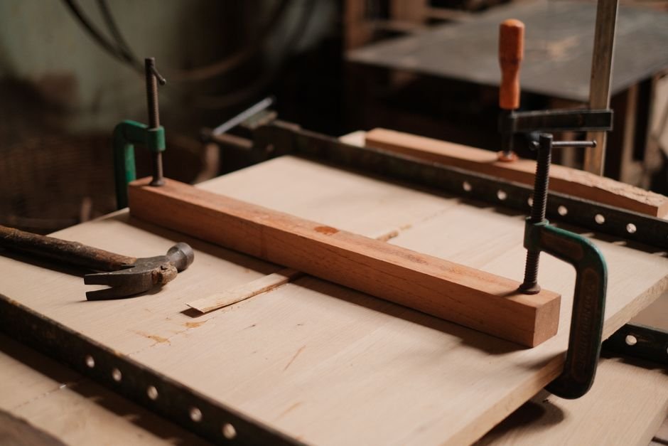 Metal clamp used in carpentry, representing the definition part of the clue